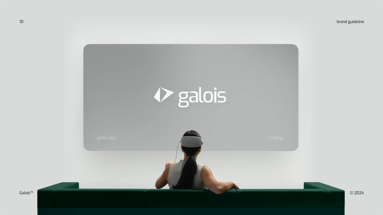 The logo on a large screen in front of a green sofa